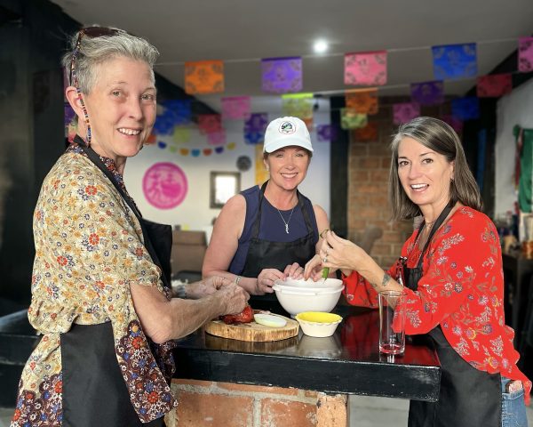 Three people preparing food together on a Spanish immersion retreat in Guanajuato.